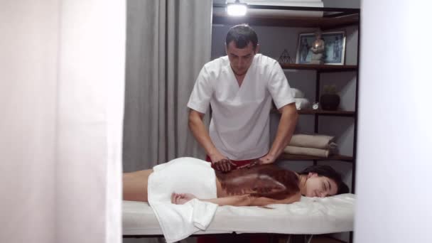 Masseur em massagens uniformes clientes de volta com máscara — Vídeo de Stock