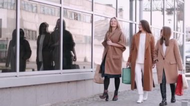 Üç kız alışveriş çantalarıyla iş başında.