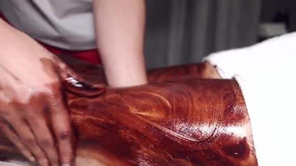 Fechar-se de homem massageando as pernas da mulher usando máscara — Vídeo de Stock