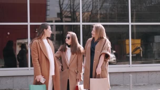 Vackra flickor kollar shoppingväskor med kläder — Stockvideo