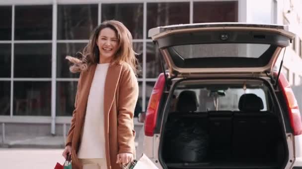 쇼핑용 가방을 차에 갖다 놓은 행복 한 여자 — 비디오
