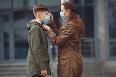 A boy and mother are wearing protective masks