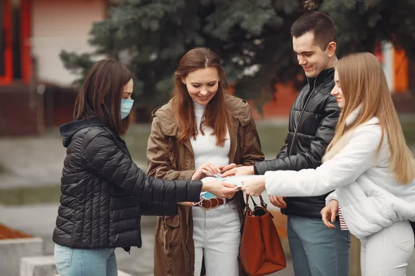 Молоді люди розповсюджують одноразові маски зовні — стокове фото