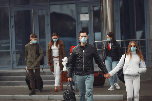 Los viajeros que salen del aeropuerto llevan máscaras protectoras. —  Fotos de Stock