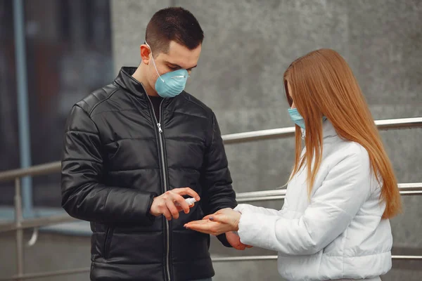 Los jóvenes que usan máscaras protectoras están rociando desinfectante para las manos —  Fotos de Stock