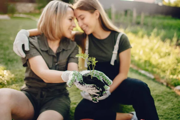 Mutter mit Tochter arbeitet im Garten in der Nähe des Hauses — Stockfoto