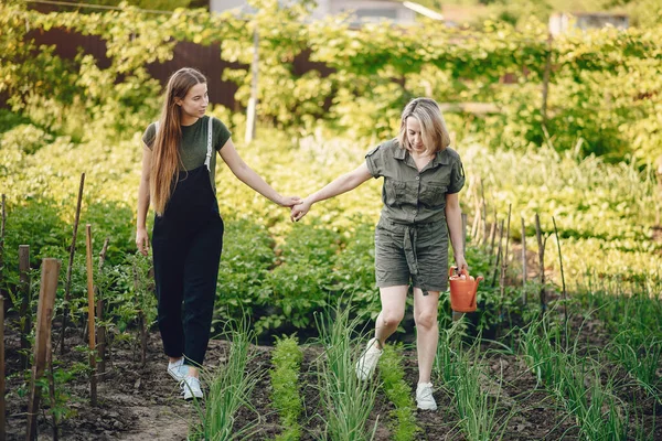 Schöne Frauen arbeiten in einem Garten in der Nähe des Hauses — Stockfoto