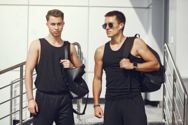 Şehirde duran spor elbiseli yakışıklı adamlar.