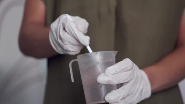 Gehakt zicht op de handen van de kunstenaar in handschoenen bereiden vloeistof — Stockvideo