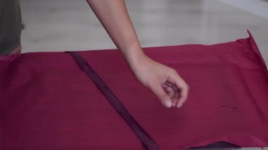 Pembe kağıtla hediye paketleyen kadınların yakın çekimi.