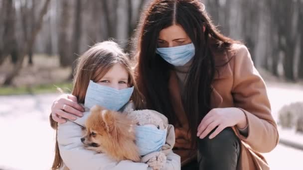 Madre europea y su hija están paseando con un perro durante la cuarentena en el parque de primavera — Vídeo de stock