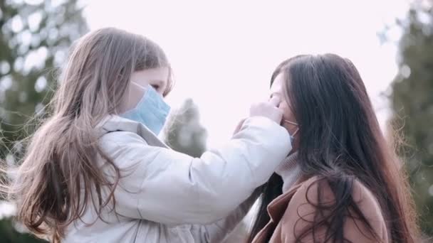 Moeder en dochter dragen wegwerpmaskers. — Stockvideo