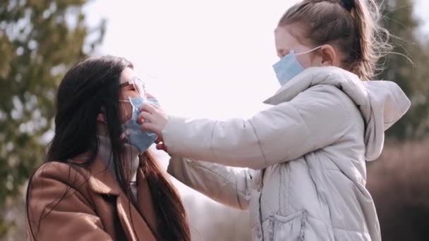 Mor och dotter bär engångsmasker. — Stockvideo