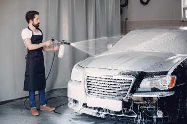 Garajda arabasını yıkayan adam