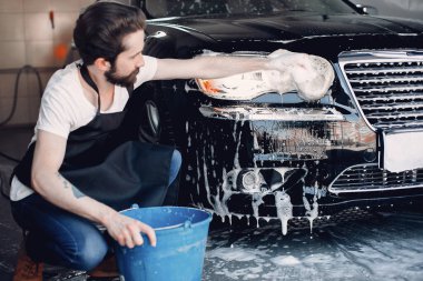 Garajda arabasını yıkayan adam