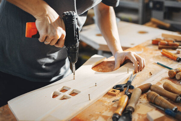 The carpenter works with a tree