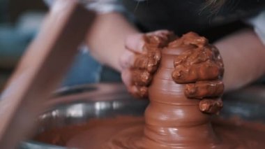 Kadın elleri çömlek çarkında çalışıyor ve esrar yapıyor.