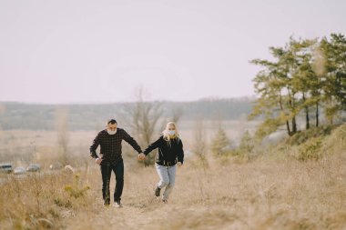 Bahar ormanlarında maskeli insanlar yürür.