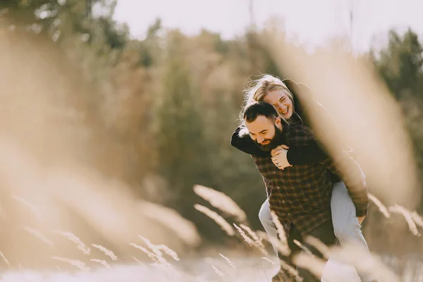 Hermosa pareja pasar tiempo en un campo de otoño — Foto de Stock