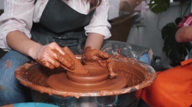 Kadın elleri çömlek çarkında çalışıyor ve esrar yapıyor.