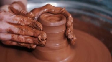 Kadın elleri çömlek çarkında çalışıyor ve esrar yapıyor.