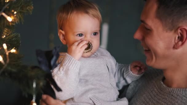 Pai segurando filho em mãos perto de árvore cristmas — Vídeo de Stock