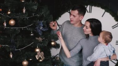 Evde Noel ağacına bakan küçük oğlu olan ebeveynler.