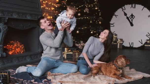 Семья с собакой распаковывает рождественские подарки дома — стоковое видео