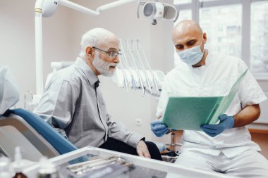 Eski diş hekimleri ofisinde oturan adam