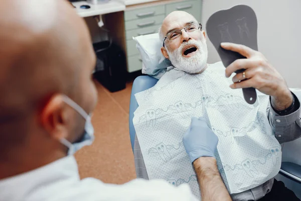 Old man sitting in the dentists office