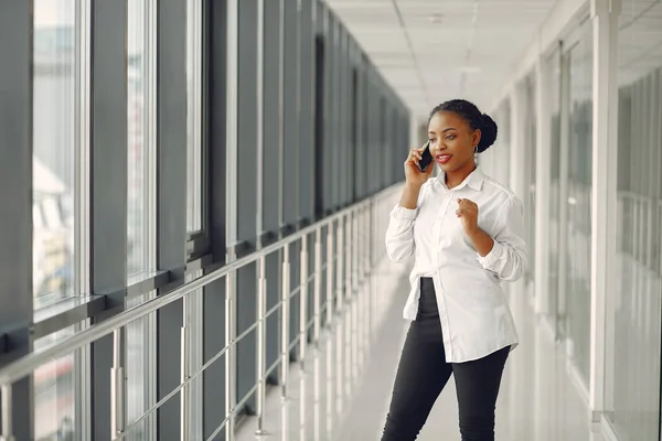 Black woman standing in the office with a laptop — Stock Photo, Image