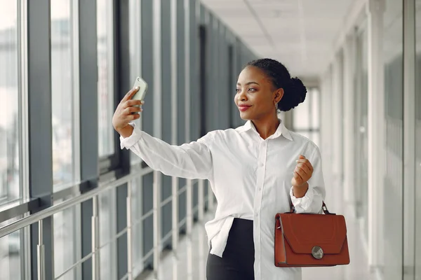 Black woman standing in the office with a laptop — Stock Photo, Image