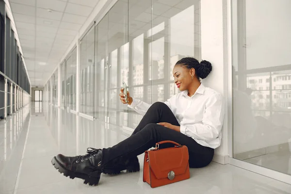 Black woman standing in the office with a laptop — Stock Photo, Image