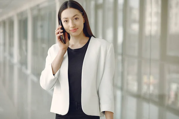 Vrouw in het kantoor met een telefoon — Stockfoto