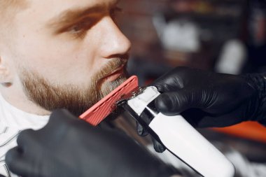 Berber dükkanında oturan şık bir adam.