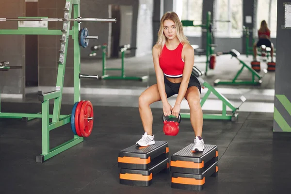 Sport blond in een sportkleding training in een sportschool — Stockfoto