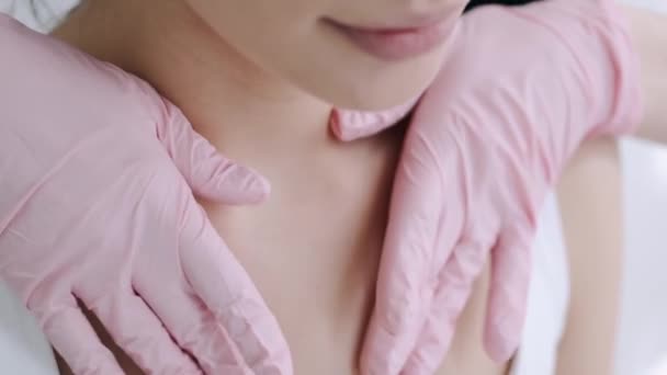 戴着粉色手套的按摩师在温泉按摩女人的脖子 — 图库视频影像