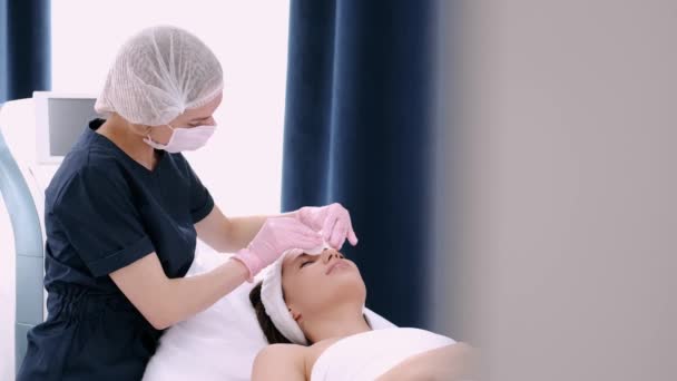 Beautician in gloves making procedure for client in beauty salon — Stock Video