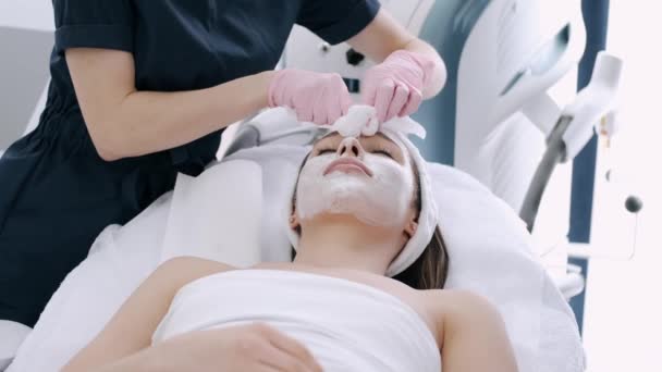 Vue recadrée de l'esthéticienne enlever le masque facial du visage — Video