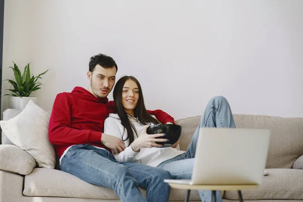 Beautiful couple watching film in a bedroom