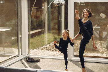 Kızı olan kadın jimnastik yapıyor.