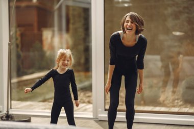 Kızı olan kadın jimnastik yapıyor.