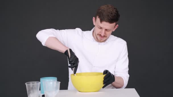스튜디오에 있는 노란 그릇에서 조리용 혼합물을 준비하는 미술가들 — 비디오