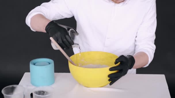 Fechar as mãos preparando mistura para modling em tigela amarela — Vídeo de Stock