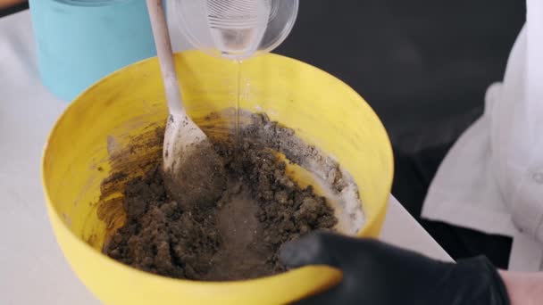 Gros plan des mains préparant le mélange pour le modelage dans un bol jaune — Video