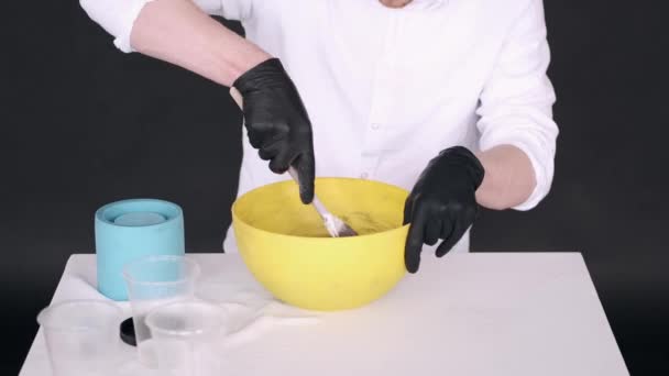 노란색 그릇에서 조제 할 수있도록 손을 감고 혼합물을 준비 한다 — 비디오