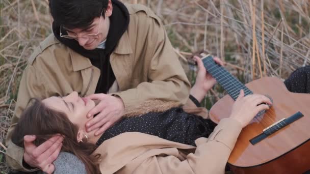 Дівчина лежить на колінах хлопців під час побачення — стокове відео