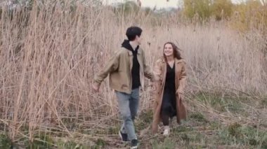 Bej ceketli genç çift dışarıda vakit geçiriyor.