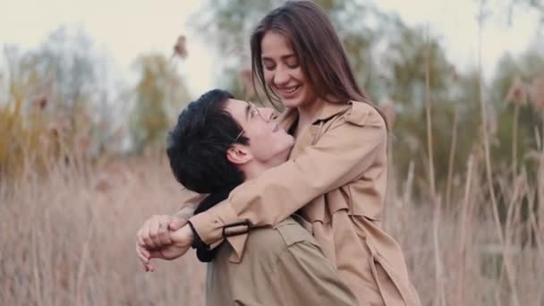 Жінка і чоловік в бежевих пальто, що зустрічаються в очереті — стокове відео