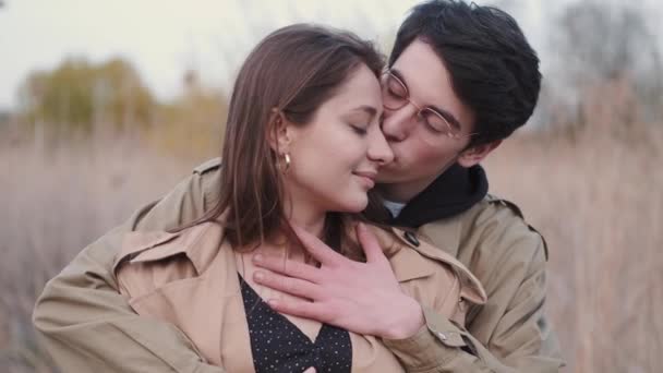 Женщина и мужчина в бежевых пальто, имеющие свидание в тростнике — стоковое видео